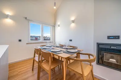 a dining room with a table and chairs and a fireplace at Marina Búzios Vilamoura Central 2-Bedroom Apartments in Vilamoura