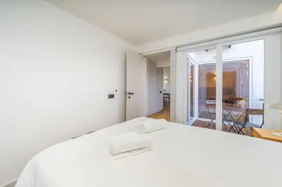 a white bedroom with a bed and a view of a room at Marina Búzios Vilamoura Central 2-Bedroom Apartments in Vilamoura