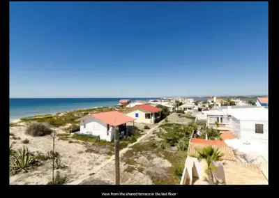 an aerial view of a beach with houses and the ocean at Blife Mariangya private rooms at Faro beach in Faro