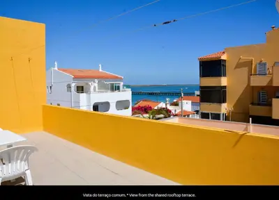 a yellow balcony with a view of the ocean at Blife Mariangya private rooms at Faro beach in Faro