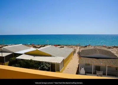 a view of a beach with buildings and the ocean at Blife Mariangya private rooms at Faro beach in Faro