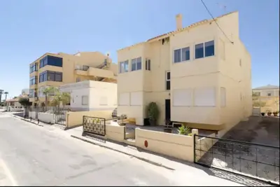 a white building on the side of a street at Blife Mariangya private rooms at Faro beach in Faro