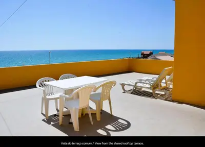 a table and chairs on a balcony with the ocean at Blife Mariangya private rooms at Faro beach in Faro