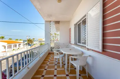 a balcony with a table and chairs and a view of the ocean at Blife Troya private rooms at Faro beach in Faro