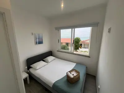a small bedroom with a bed and a window at Blife Troya private rooms at Faro beach in Faro