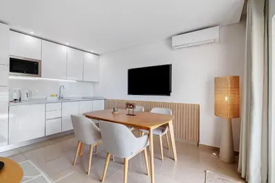 a kitchen and dining room with a wooden table and chairs at Marina Mar in Vilamoura