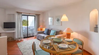 a living room with a table and a couch at Superior Two Bedroom Apartment in Clube Albufeira in Albufeira