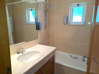 a bathroom with a sink and a shower with a mirror at Superior Two Bedroom Apartment in Clube Albufeira in Albufeira