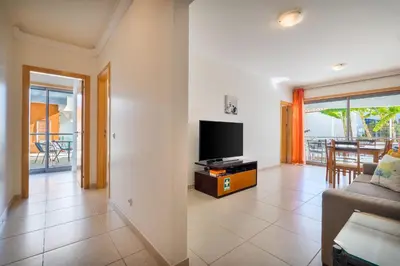 a living room with a tv and a couch at Bright 2BR with Pool near Beach by LovelyStay in Albufeira