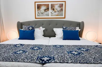 a bedroom with a bed with blue and white pillows at Sunflower Apartments by Delilah Collection in Albufeira