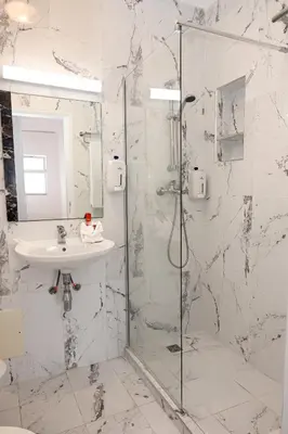 a bathroom with a glass shower and a sink at Sunflower Apartments by Delilah Collection in Albufeira