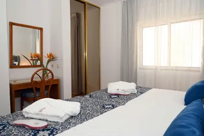 a bedroom with a bed with two towels on it at Sunflower Apartments by Delilah Collection in Albufeira