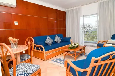 a living room with a blue couch and chairs at Sunflower Apartments by Delilah Collection in Albufeira