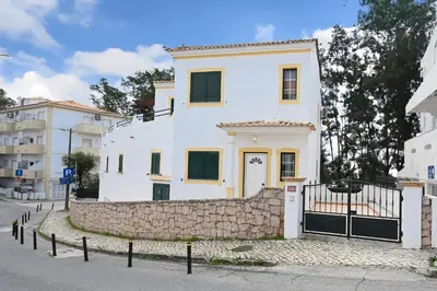 a white house with a stone wall at Villa Simões by Delilah Collection in Albufeira