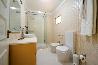 a bathroom with a toilet and a sink and a tub at Sunrise Beach Villa by Delilah Collection in Albufeira