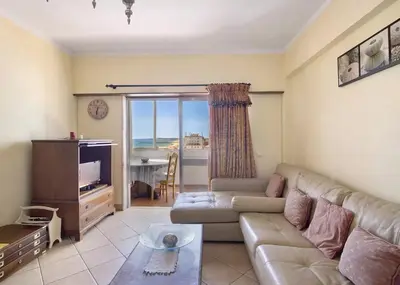 a living room with a couch and a tv at VIP T2 Beachfront with Garage in Quarteira
