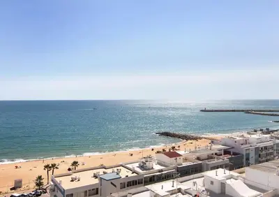 a view of a beach with buildings and the ocean at VIP T2 Beachfront with Garage in Quarteira