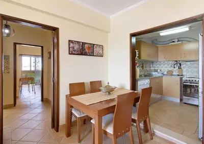a kitchen and dining room with a wooden table and chairs at VIP T2 Beachfront with Garage in Quarteira