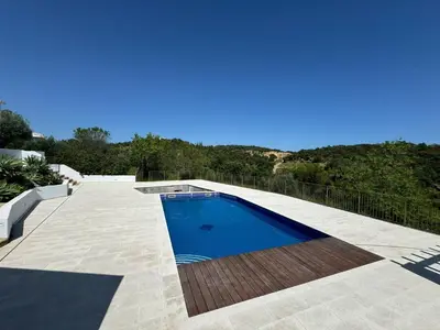 a swimming pool on the side of a house at Quinta do Olival - Casa Faro Oeste - Calm & wellness in São Brás de Alportel