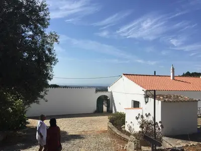 a man and two women walking towards a white building at Quinta do Olival - Casa Limão - Calm & wellness in São Brás de Alportel