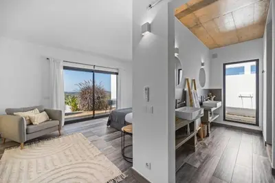 a white room with a bed and a sink and a bathroom at Amazing Views Villa in Loulé