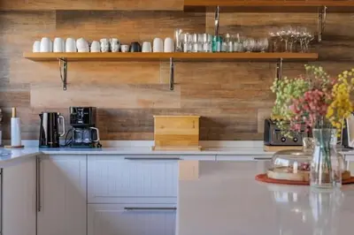 a kitchen with white cabinets and a wooden wall at Amazing Views Villa in Loulé