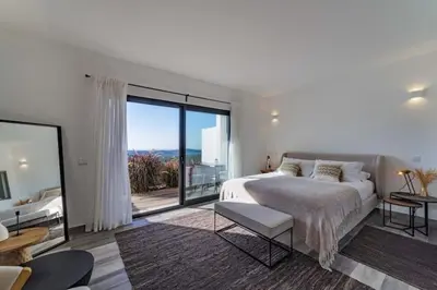 a white bedroom with a bed and a large window at Amazing Views Villa in Loulé