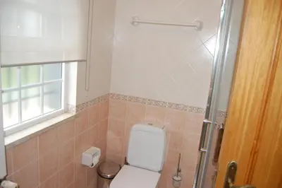 a bathroom with a toilet and a window and a shower at Villa Monte Alegrete with sea view in Faro