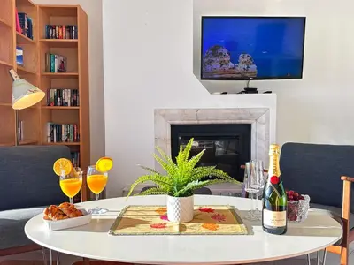 a living room with a table and a fireplace at WindMill Rooftop Panoramic OceanView Condo By BeCherish in Albufeira