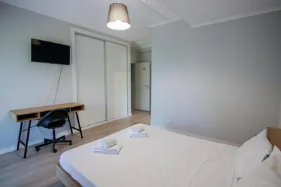 a bedroom with a bed and a desk and a computer at QUANICE - Relaxing Guest House in Faro in Faro