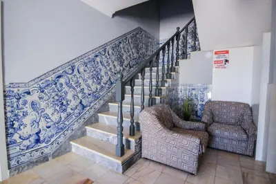 a stairway with a chair and a stair case at QUANICE - Relaxing Guest House in Faro in Faro