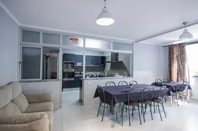 a living room with a table and chairs and a kitchen at QUANICE - Relaxing Guest House in Faro in Faro
