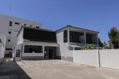 a white house with a white fence in front of it at QUANICE - Relaxing Guest House in Faro in Faro