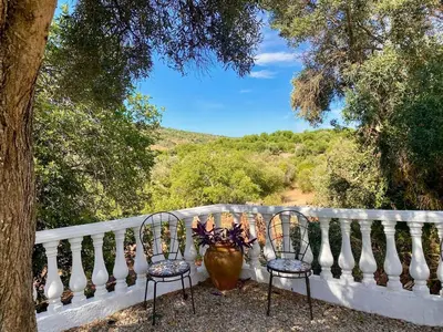 two chairs and a vase sitting on a balcony at Casa Mariano Private Heated Pool With Views and AC