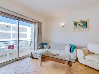 a living room with a couch and a glass table at Colina Beach Holidays, 2 bdr Apartment Quarteira in Quarteira
