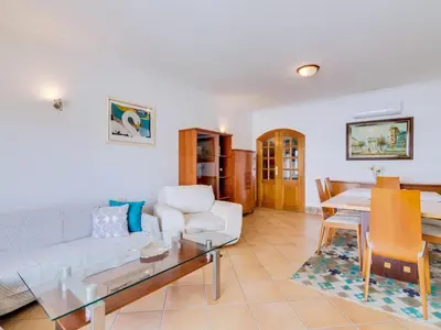 a living room with a white couch and a table at Colina Beach Holidays, 2 bdr Apartment Quarteira in Quarteira