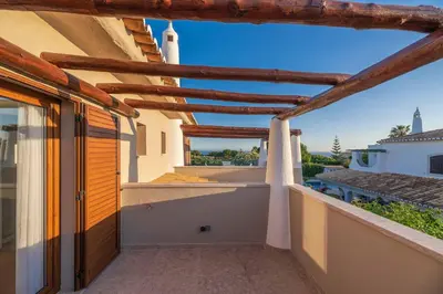 a balcony of a house with a wooden roof at Casa da Praia in Galé