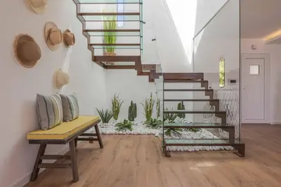 a living room with a staircase and a bench and plants at Casa da Praia in Galé