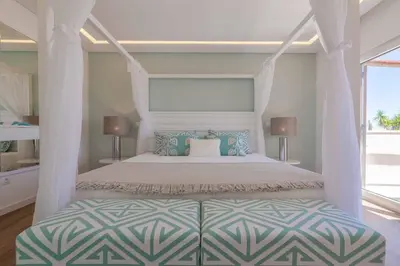 a bedroom with a white bed with a canopy at Casa da Praia in Galé