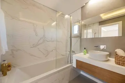 a bathroom with a tub and a sink and a shower at Casa da Praia in Galé