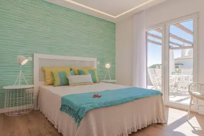a bedroom with a bed in a room with a balcony at Casa da Praia in Galé