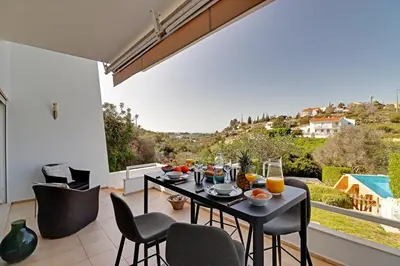 a dining room with a table and chairs on a balcony at Terras Novas Albufeira in Albufeira