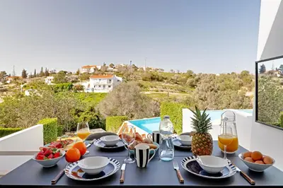 a table with food and fruit on a balcony with a view at Terras Novas Albufeira in Albufeira