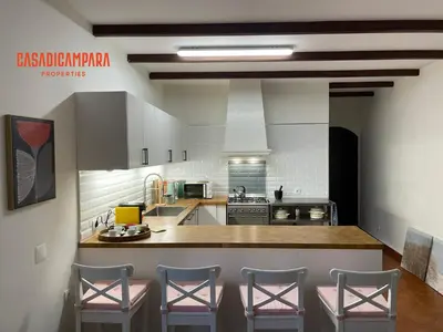 a kitchen with a counter and four chairs in it at Casa di Campara Almada Villa in FAO