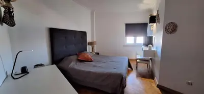 a small bedroom with a bed and a desk at Location la vue sur mer in Albufeira