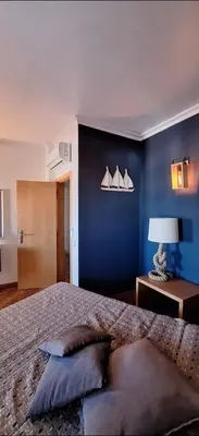 a bedroom with a large bed with a blue wall at Location la vue sur mer in Albufeira