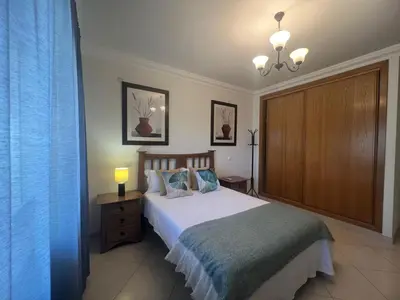 a bedroom with a bed and a chandelier at Praia Village by Garvetur in Quarteira