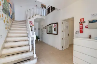 a staircase in a room with white walls and a stair case at Blife Sunya private rooms near airport and nature in Faro