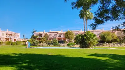 a park with a palm tree in front of a building at Casa Balaia in Olhos de Água