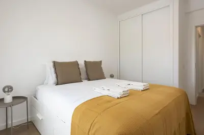 a bedroom with a white bed with a yellow blanket on it at Alva - cozy apartment with pool by HD in Vilamoura